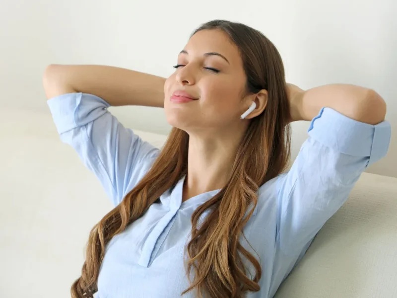 Frau mit Kopfhörer auf Couch